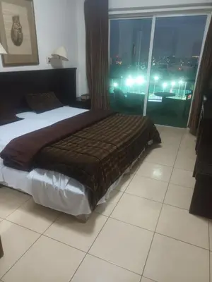 a bedroom with a bed with a view of a city at CITYRISEHOTELINAMMAn in Al Jafr