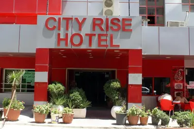 a city rise hotel with plants in front of it at CITYRISEHOTELINAMMAn in Al Jafr