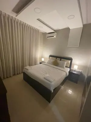 a bedroom with a bed and two night stands with lamps at apartment 60m 1bedroom for rent4 in Amman