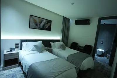 a hotel room with two beds and a desk at Roya Downtown Boutique Hotel in Amman