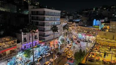 a busy city street at night with cars and buildings at Roya Downtown Boutique Hotel in Amman
