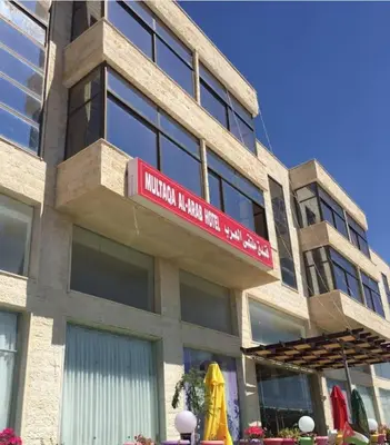 a building with a red sign on the side of it at Althemar Hotel Ajloun -Jordan By Enala Hotels Group in Ajloun