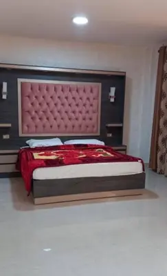 a bedroom with a large bed with a red headboard at Althemar Hotel Ajloun -Jordan By Enala Hotels Group in Ajloun
