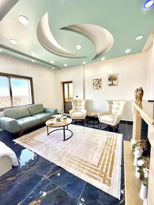 a living room with a couch and a table at Luxury 2 Bedroom Apartment in Amman