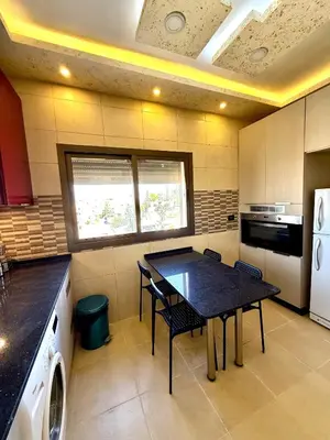 a kitchen with a black table and chairs in it at Luxury 2 Bedroom Apartment in Amman