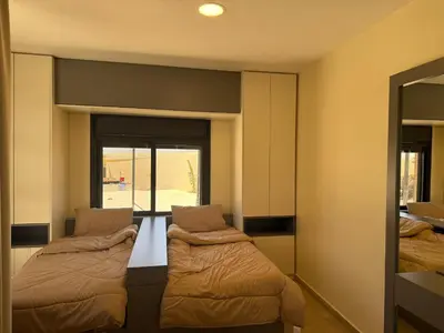 a room with two beds and a mirror at Giving Vibes Chalet in Amman