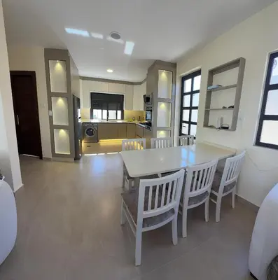 a kitchen and dining room with a table and chairs at Giving Vibes Chalet in Amman