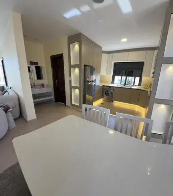 a kitchen with a white table and chairs in a room at Giving Vibes Chalet in Amman