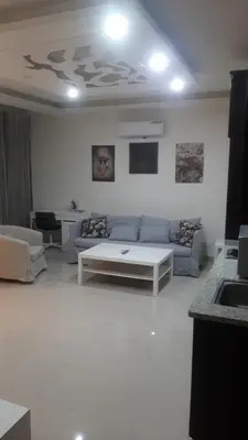 a living room with a couch and a table at Al-Amaari Gardens Compound 3092 in Irbid
