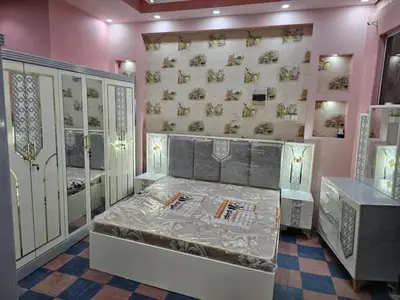 a room with a bed and a wall with paintings at Tea apartment in Aqaba