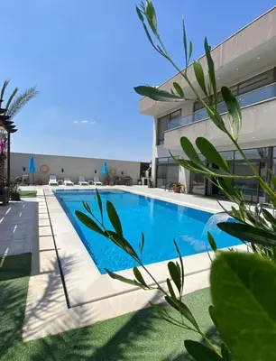 a swimming pool in front of a building at Sunshine Chalet in Shūnat Nimrīn