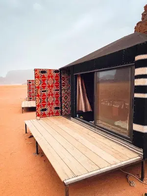 a house in the desert with a wooden deck at Bubble Camp Wadi Rum in Wadi Rum