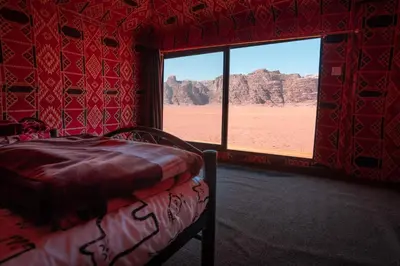 a bedroom with a bed and a view of the desert at Bubble Camp Wadi Rum in Wadi Rum