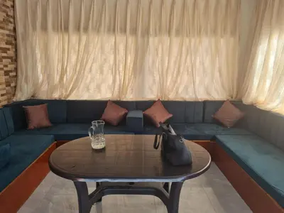 a living room with a blue couch with a table at شاليهات إيليت بانوراما فيو in Jerash