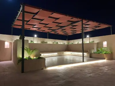 a swimming pool under a pergola at night at شاليهات إيليت بانوراما فيو in Jerash