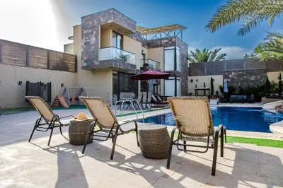 a patio with chairs and a swimming pool at Bahama-Oriya chalets in Al Rama