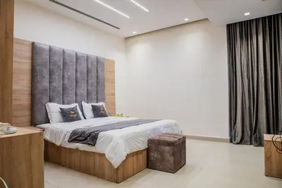 a bedroom with a large bed with a gray headboard at Bahama-Oriya chalets in Al Rama