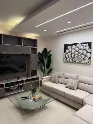 a living room with a couch and a tv at Bahama-Oriya chalets in Al Rama
