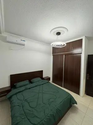 a bedroom with a green bed and a closet at stay by university of Jordan in Amman