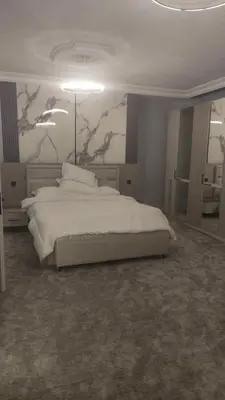 a bedroom with a white bed and a painting on the wall at بيت محمد in Amman