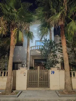 a building with palm trees in front of a gate at بيت محمد in Amman