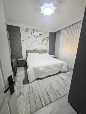a bedroom with a large white bed and a rug at بيت محمد in Amman