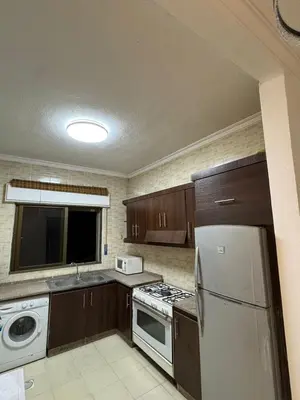 a kitchen with a white refrigerator and a stove at stay by university of Jordan in Amman