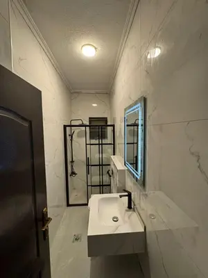 a white bathroom with a sink and a mirror at stay by university of Jordan in Amman