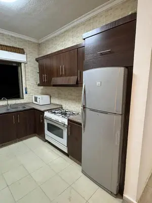 a kitchen with a stainless steel refrigerator and a stove at stay by university of Jordan in Amman