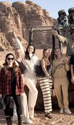a group of people posing for a picture in the desert at Celestial Mirage Camp in Wadi Rum