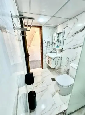 a white bathroom with a toilet and a sink at Celestial Mirage Camp in Wadi Rum