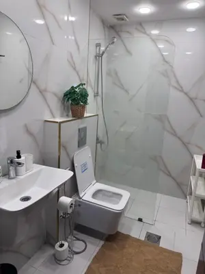 a bathroom with a toilet and a sink and a shower at Glow and Grace in Abdoun Best location in Amman