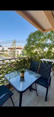 a table and chairs on a balcony with a potted plant at Glow and Grace in Abdoun Best location in Amman