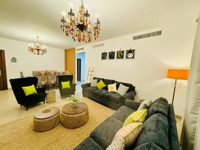 a living room with a couch and chairs and a chandelier at Loom & Light In the best location in Abdoun Amman in Amman
