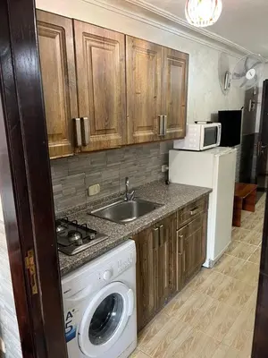 a kitchen with a sink and a washing machine at Central modern affordable studio in Amman