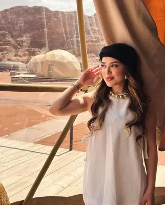 a woman wearing a hat standing next to a window at RUM MAGIC BUBBLE lUXURY CAMP in Wadi Rum