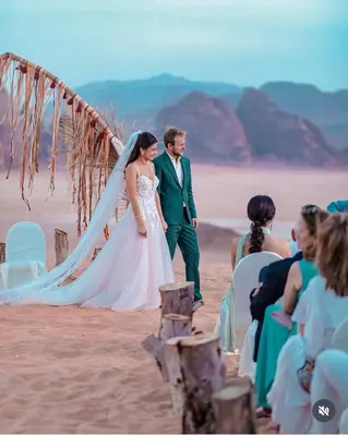 a bride and groom walking down the beach at RUM MAGIC BUBBLE lUXURY CAMP in Wadi Rum