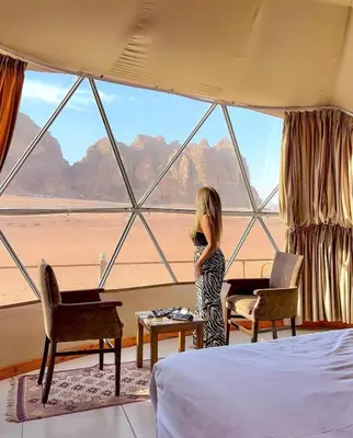 a little girl standing in a room with a large window at RUM MAGIC BUBBLE lUXURY CAMP in Wadi Rum