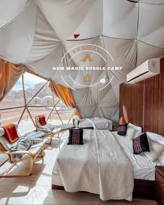a bedroom with a bed and chairs in a tent at RUM MAGIC BUBBLE lUXURY CAMP in Wadi Rum