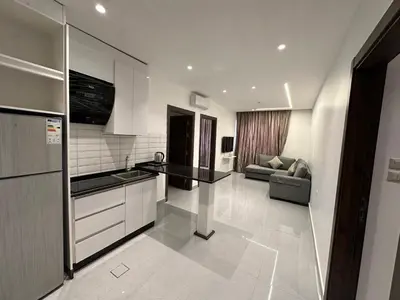 a kitchen and living room with a couch in a room at Masaken Hotel Apartment in Amman