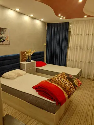 a bedroom with two beds and a leopard blanket at روف بانورامي باطلاله رائعه يسمح فقط للبنات او زوج وزوجة العمارة عائلية in Amman