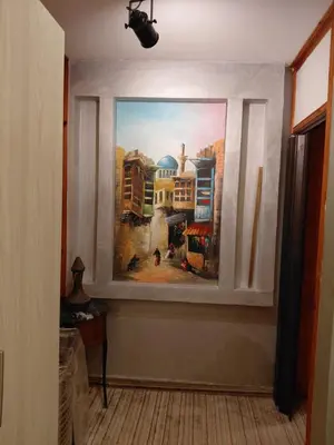 a painting on the wall of a room with a window at روف بانورامي باطلاله رائعه يسمح فقط للبنات او زوج وزوجة العمارة عائلية in Amman