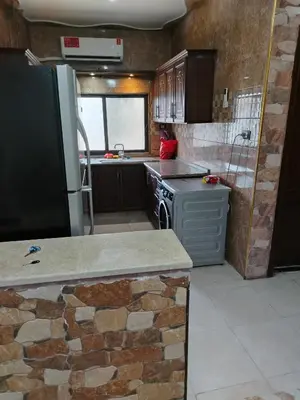a kitchen with a refrigerator and a stove in it at الشقة الفاخرة Luxerios apartment in 0MM Nowwara in Amman