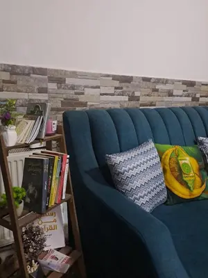 a blue couch with pillows on it in a room at شقة مميزة in Rujm Maghghijhah