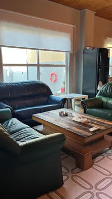 a living room with couches and a coffee table at T Cozy Chalet in Ash Shāghūr