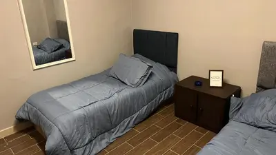 a bedroom with two beds and a table with a mirror at T Cozy Chalet in Ash Shāghūr