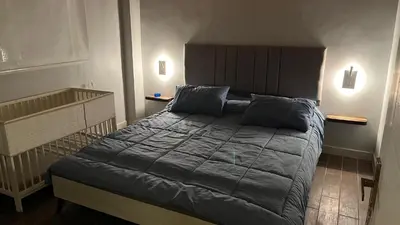 a bedroom with a large bed with blue pillows at T Cozy Chalet in Ash Shāghūr