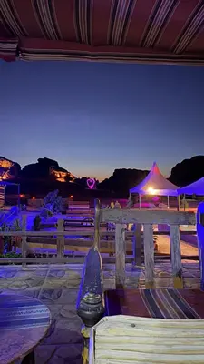 a bench with a view of a beach at night at Rotana Wadi Rum in Wadi Rum