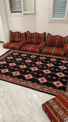 a couch in a living room with a rug at Musa apartment in Petra