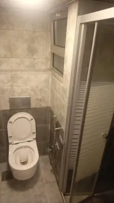 a small bathroom with a toilet and a shower at lNTERCoNTlNENTALAL in Amman